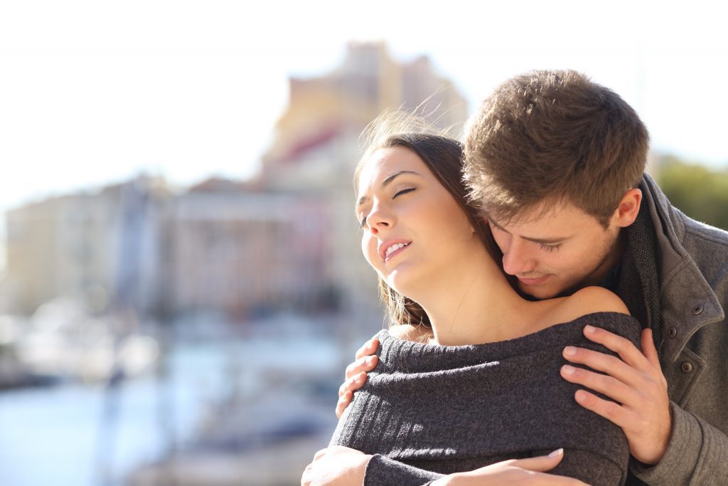 man hugging woman from behind