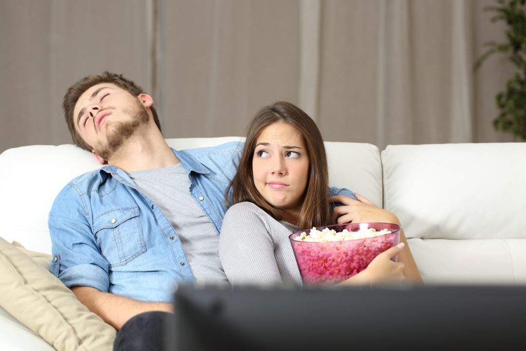 man groaning at girlfriend on couch