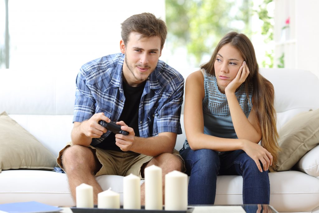 woman bored while boyfriend plays video games