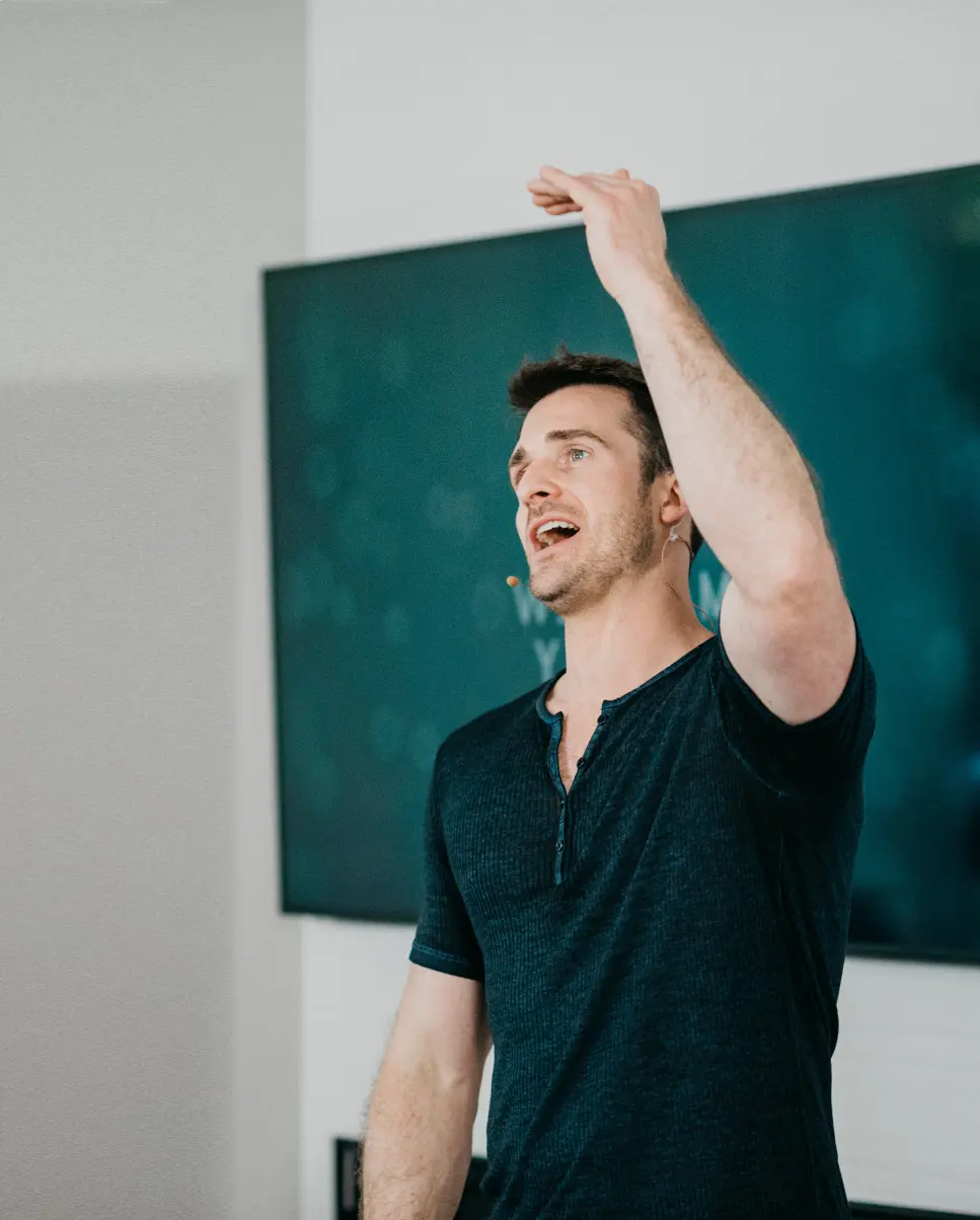 An image of Matthew Hussey raising his hand above his head